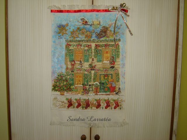 Enfeite de porta Casa do Papai Noel. Tcnica: dcoupage em tecido com guardanapo, pintura em relevo com tinta puff e lao de fitas.